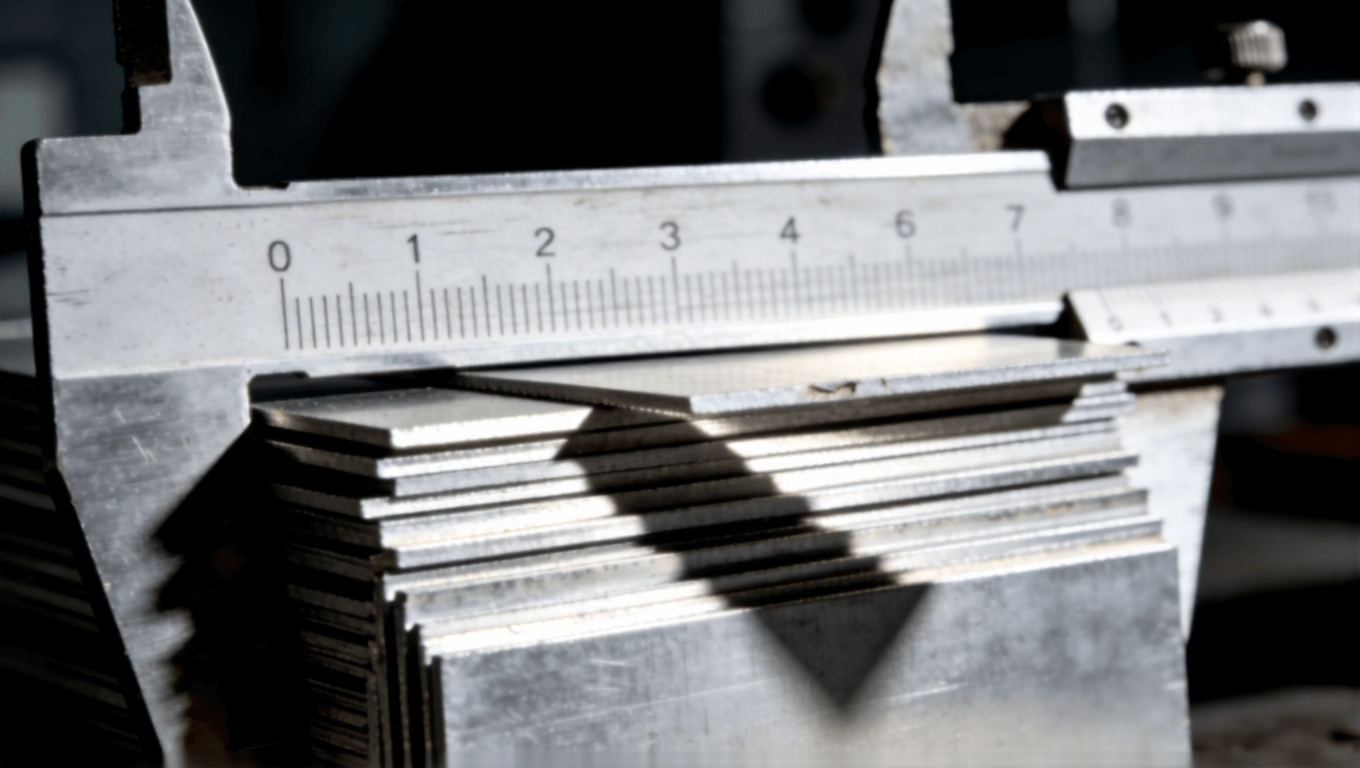 微距摄影展示铝基板厚度公差，卡尺测量下参差交错，侧光凸显缝隙与阴影